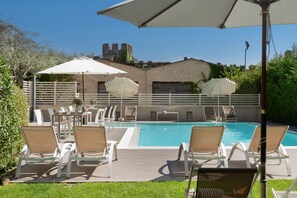 Piscine extérieure, parasols de plage, chaises longues