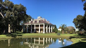 A large, historic building with a symmetrical facade and a central tower, surrounded by a well-maintained lawn and a pond with swans. - SpringHill Suites by Marriott Baton Rouge Gonzales (Gonzales)