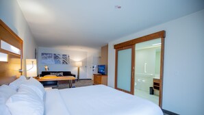 A hotel room with a large bed, a desk with a chair, a television, and a sliding door leading to a bathroom. - SpringHill Suites by Marriott Baton Rouge Gonzales (Gonzales)