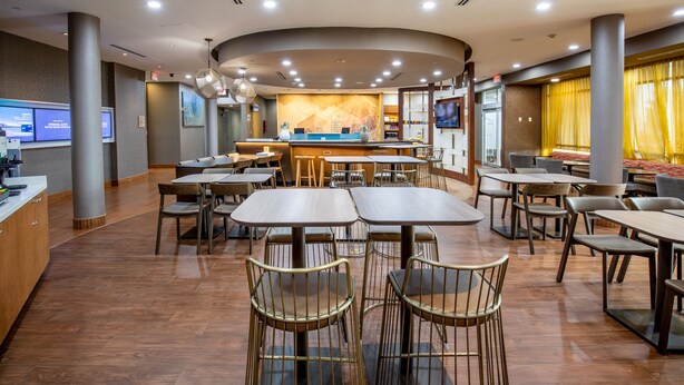 A spacious hotel lobby with multiple seating areas, a reception desk, and a large digital display. - SpringHill Suites by Marriott Baton Rouge Gonzales (Gonzales)