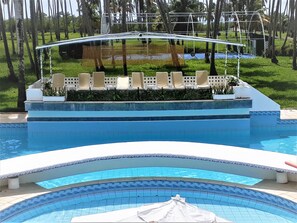 Una piscina al aire libre, sillones reclinables de piscina