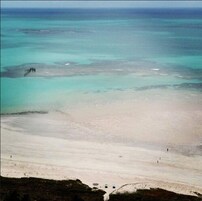 Na praia, espreguiçadeiras, guarda-sóis, toalhas de praia 