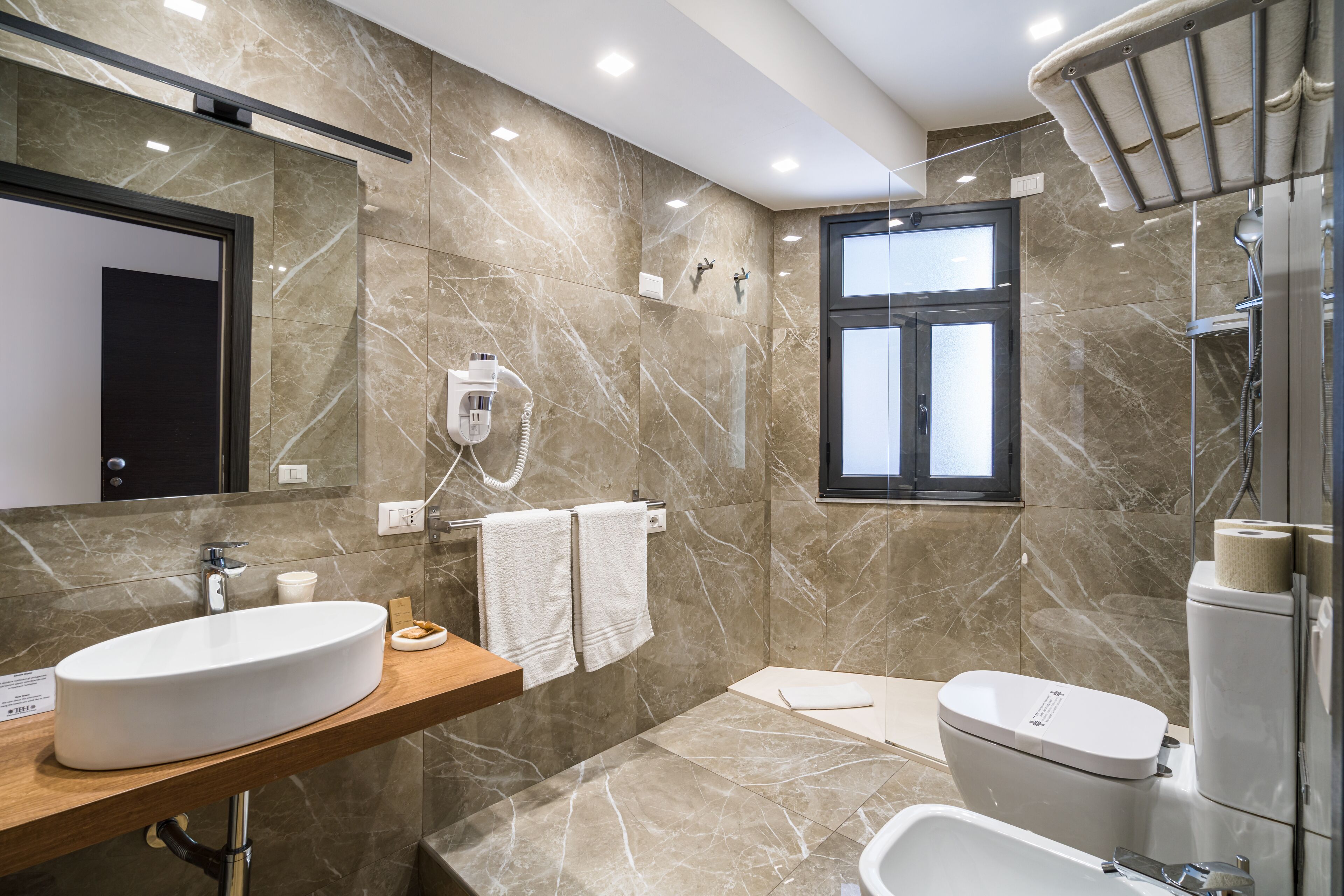 Un baño moderno con lavamanos de mármol, bañera y retrete.