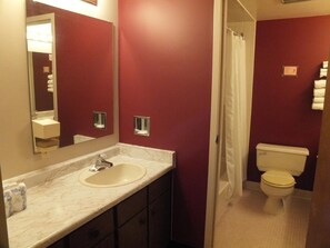 Een bad/douchecombinatie, een haardroger, handdoeken