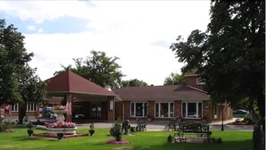 Een twee verdiepingen tellend huis met een voortuin, een gazon en een oprit.