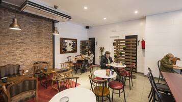 A café with brick walls, wooden furniture, and pendant lighting.