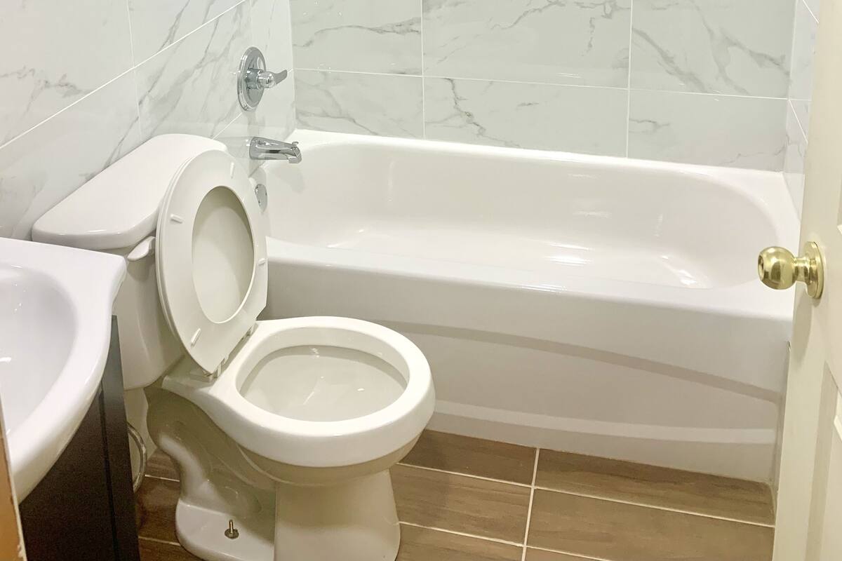 A bathroom with a bathtub, toilet, and sink.