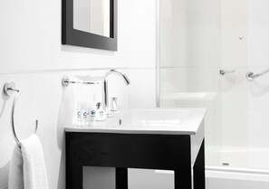 Superior studio suite | Badkamer | Een bad/douchecombinatie, een diep bad, een regendouche