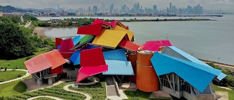 Un edificio moderno con una estructura de techo única y colorida cerca de la costa.