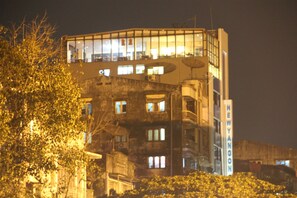 Um edifício de vários andares com fachada de vidro e uma placa com a inscrição 'NEWYANGON'.