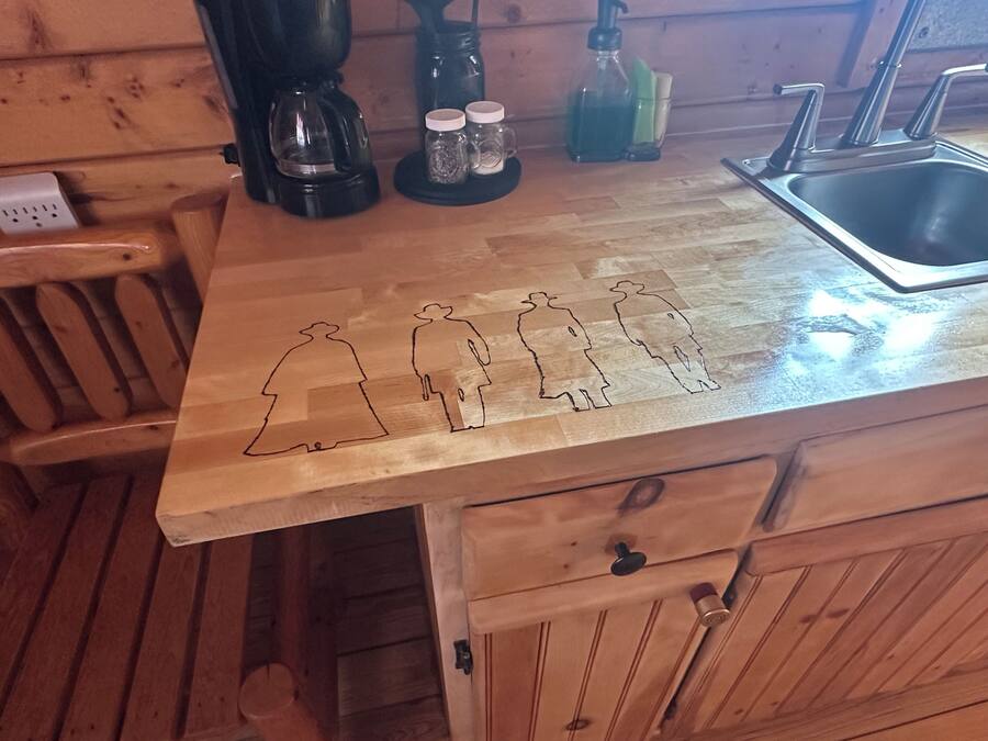 A wooden kitchen counter with a coffee maker, salt and pepper shakers, and a bottle of dish soap.