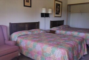 A hotel room with two beds, a chair, and a nightstand with lamps. - Ken-Bar Lodge (Gilbertsville)