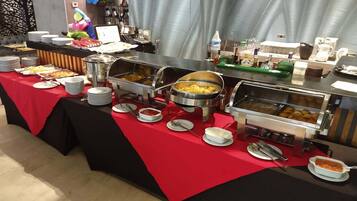 Un bufé con diversos alimentos y utensilios para servir.