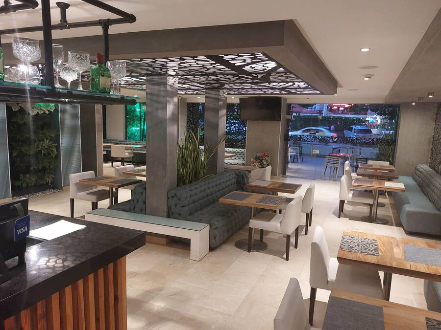 A modern interior with seating areas, a bar, and a view of the street.