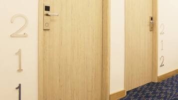 A hallway with wooden doors numbered 1 and 2, a metal handle, and a patterned carpet.