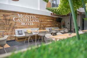 A modern hotel lobby with wooden accents, comfortable seating, and a clear view of the hotel name on the wall. - Montes de la Castellana Hotel Boutique (Armenia)