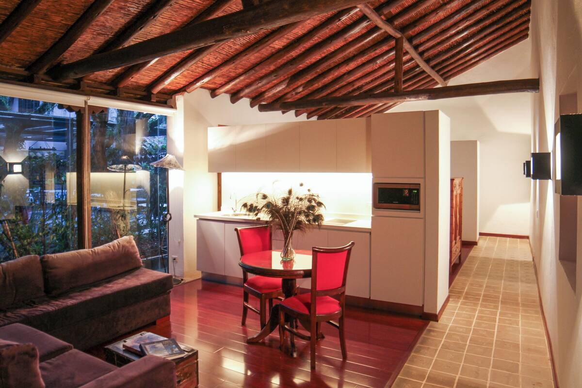 Una cocina moderna con zona de comedor, suelo de madera y vistas a través de un ventanal.