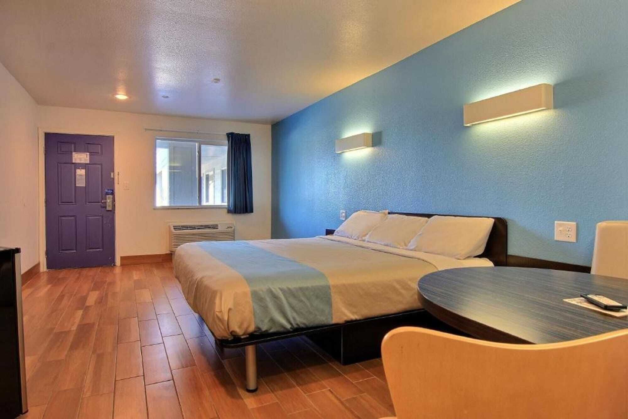 A hotel room with a bed, a desk, and a chair.