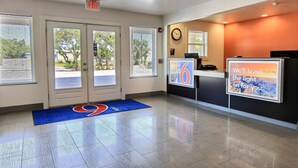 A reception area with a clock, a digital display, and a sign that says "We'll leave the light on for you."