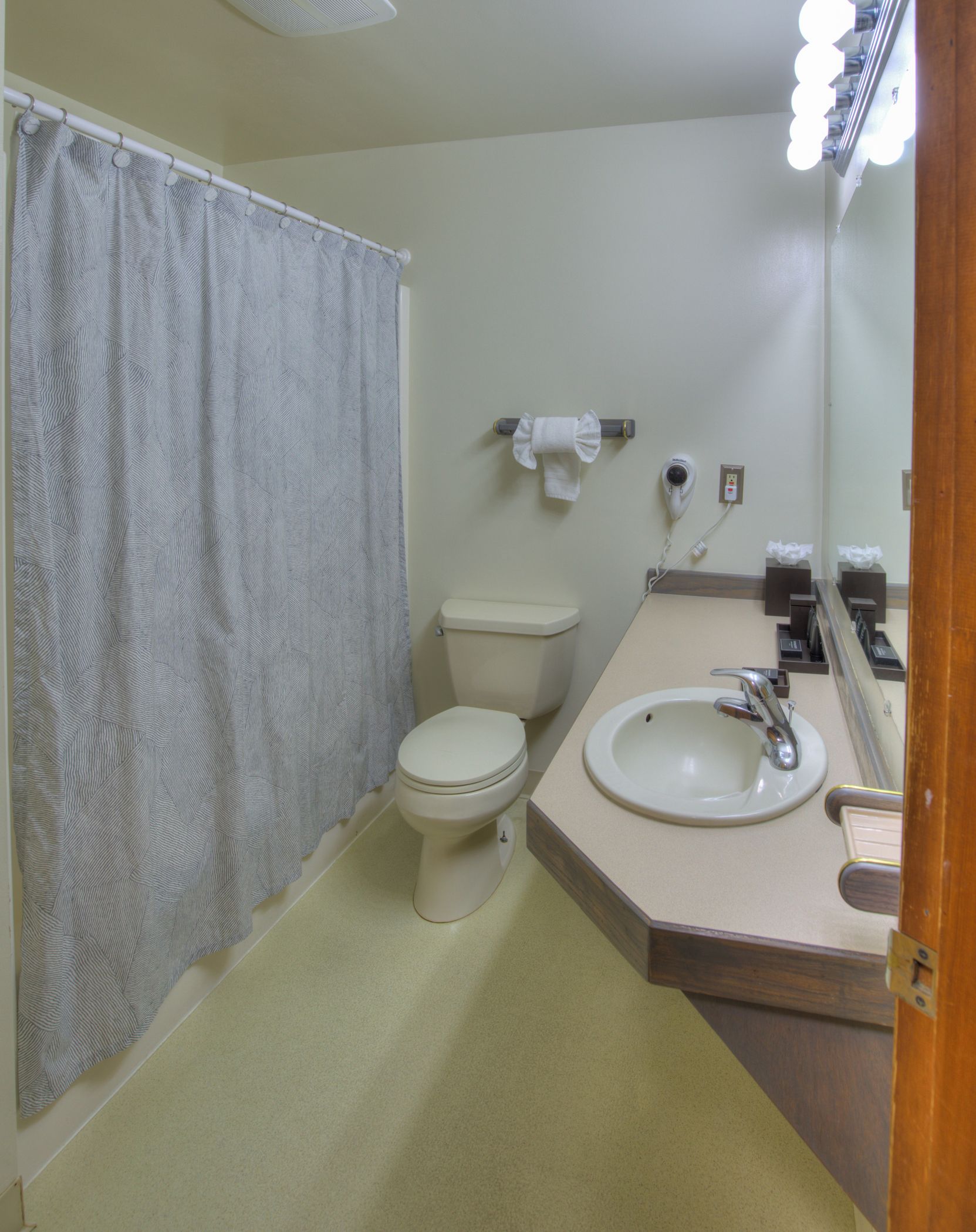 A bathroom with a toilet, sink, and a shower curtain.