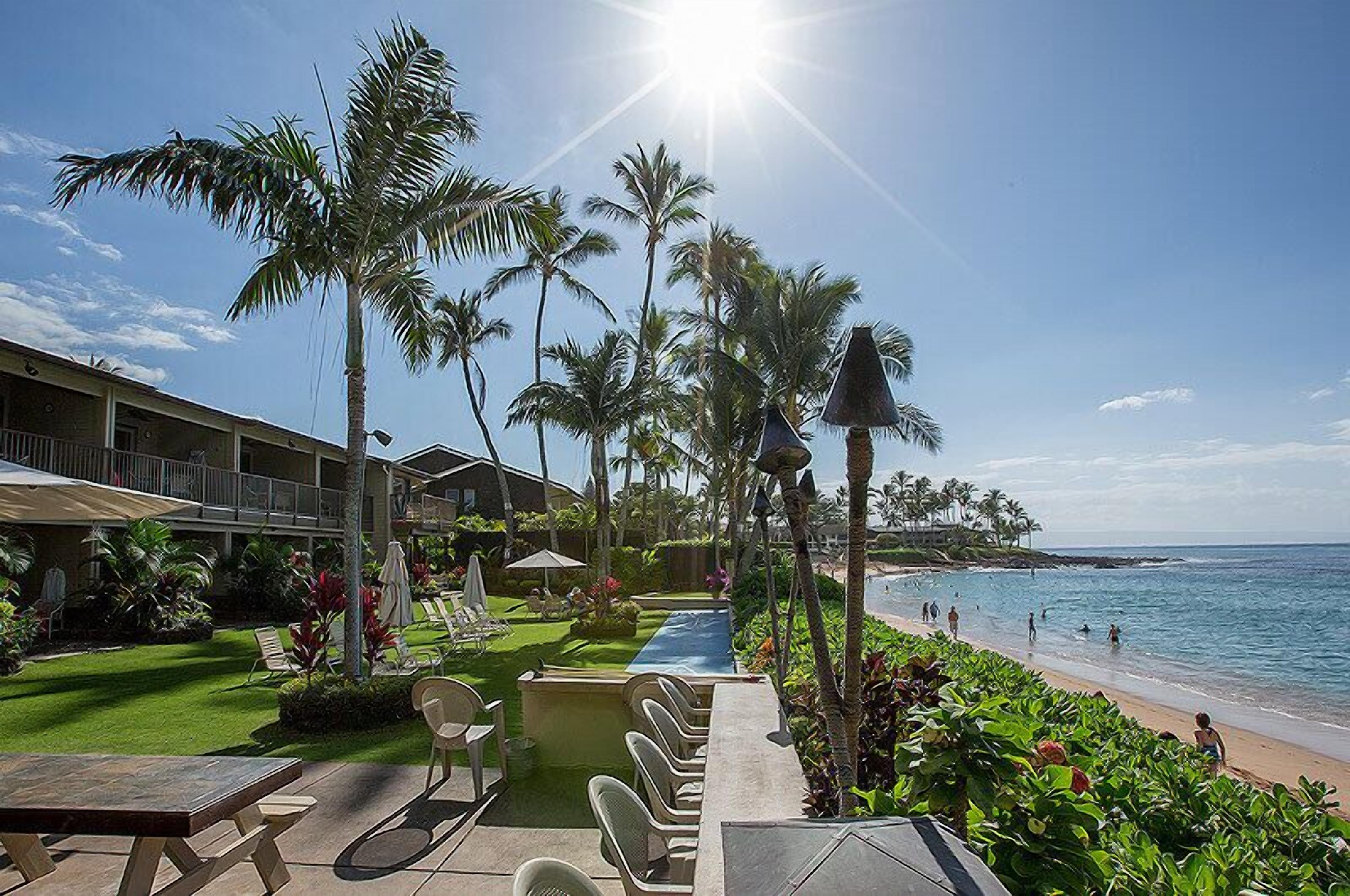 A resort with a pool, lounge chairs, and a view of the beach.
