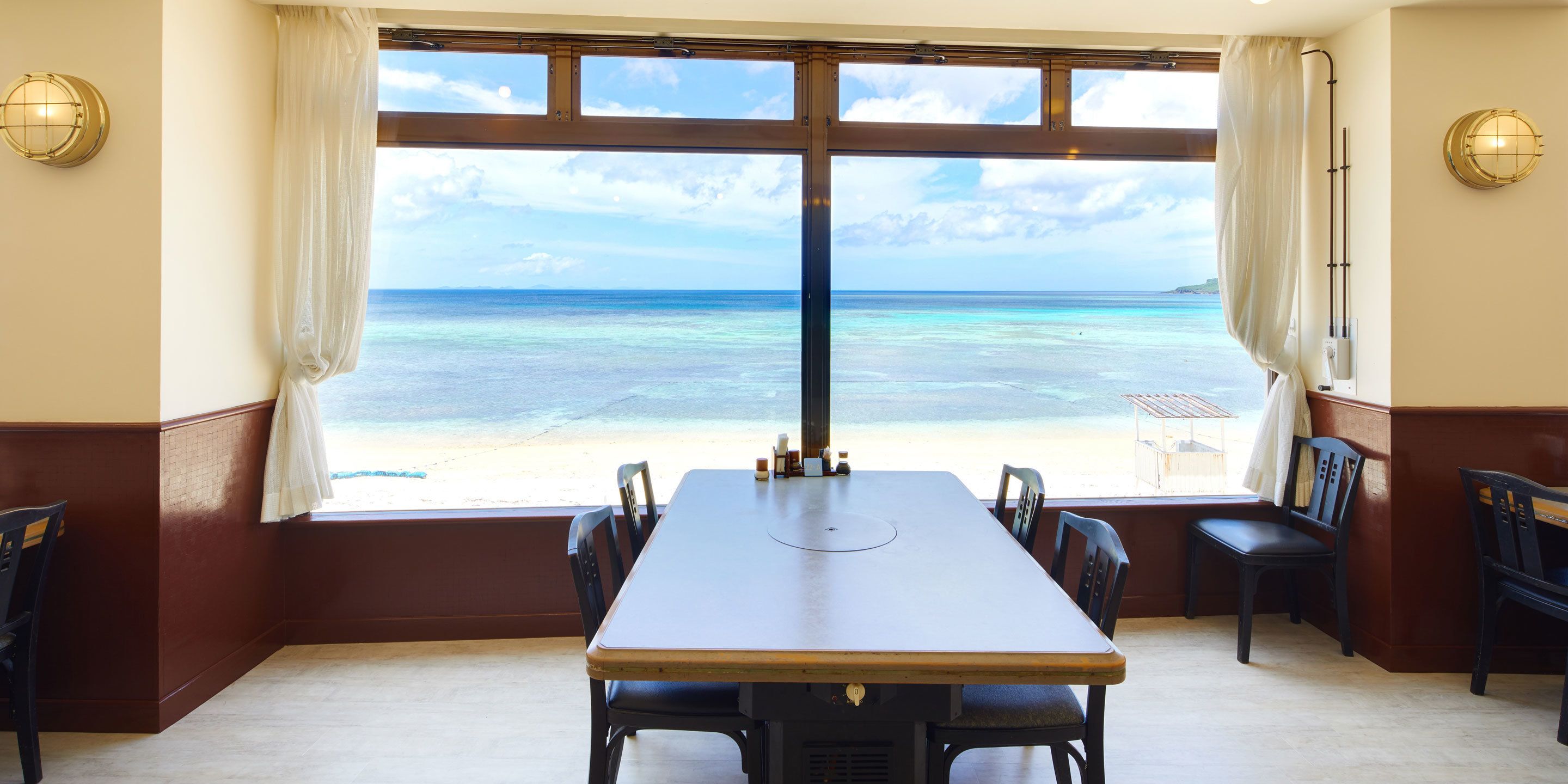 A dining area with a view of the beach.