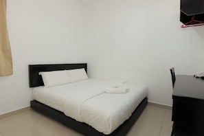 A single bed with a black headboard, a white bedspread, and a rolled towel on the bed. - Hotel Alam Indi (Johor Bahru)
