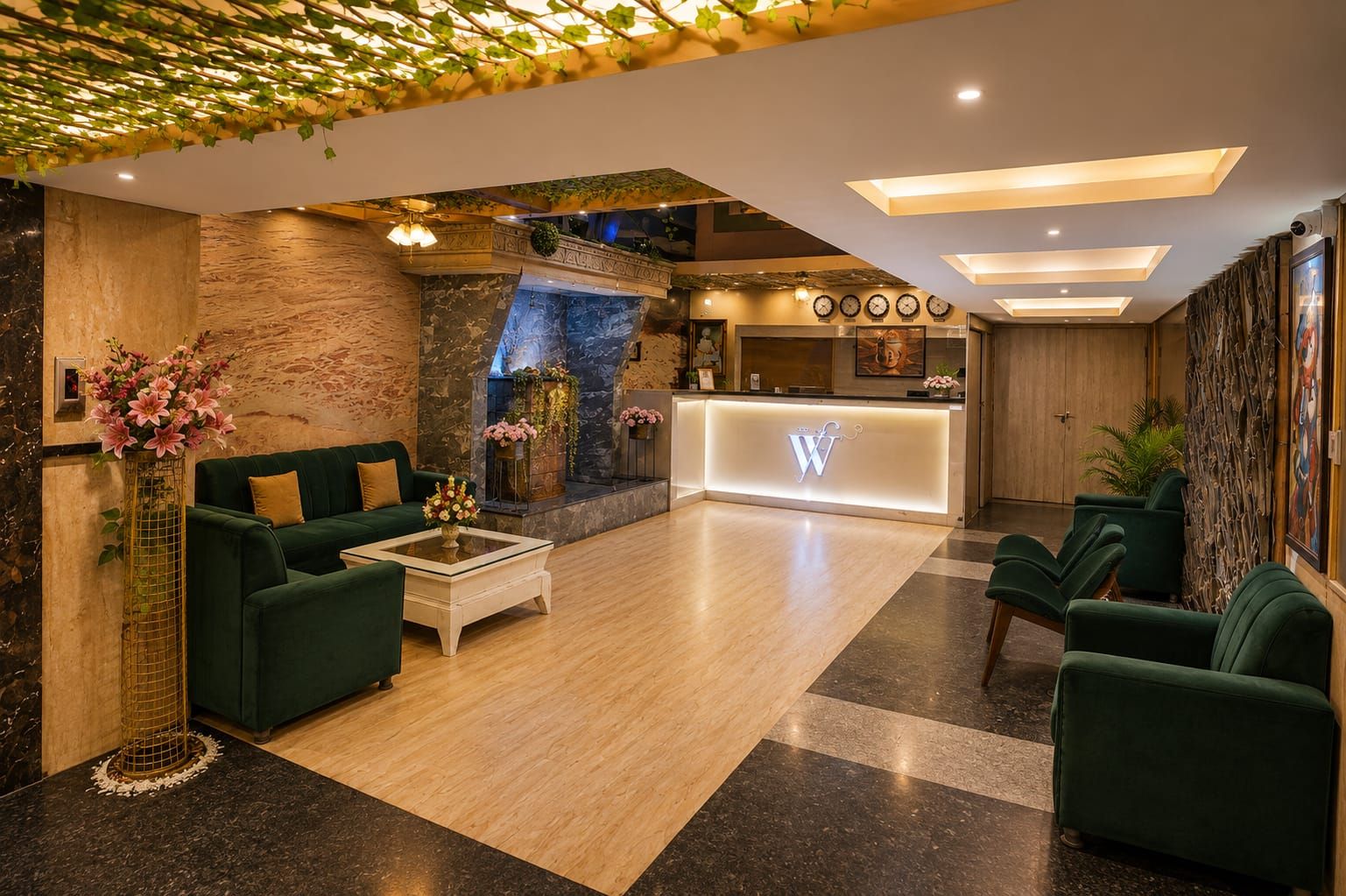 Eine Lobby mit einer Rezeption, grünen Sofas, einem Couchtisch, einem Kamin und einer Steinwand.