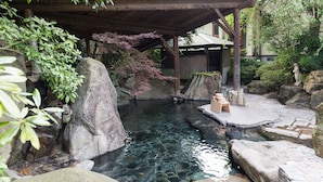 A serene garden with a clear pond, large rocks, and a wooden pavilion. - Pension Yufuin (Yufu)