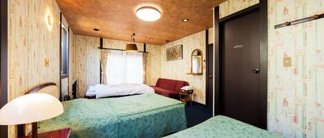 A hotel room with two beds, a wooden ceiling, a mirror, and a door labeled "TOILET".