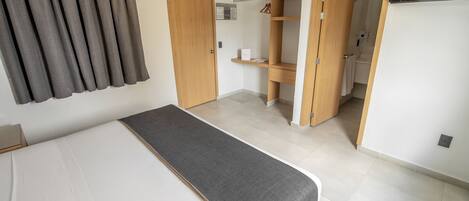 Ein Schlafzimmer mit Bett, Kleiderschrank und Fernseher.