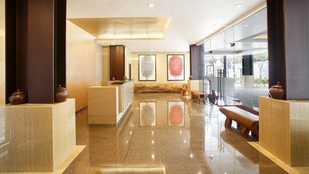 Una hall moderna con una reception, area salotto e opere d'arte alle pareti.
