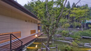Un edificio de estilo japonés tradicional con un estanque de carpas y un puente de madera.