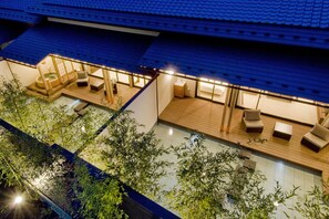 A rooftop terrace with a hot tub, seating area, and bamboo plants.
