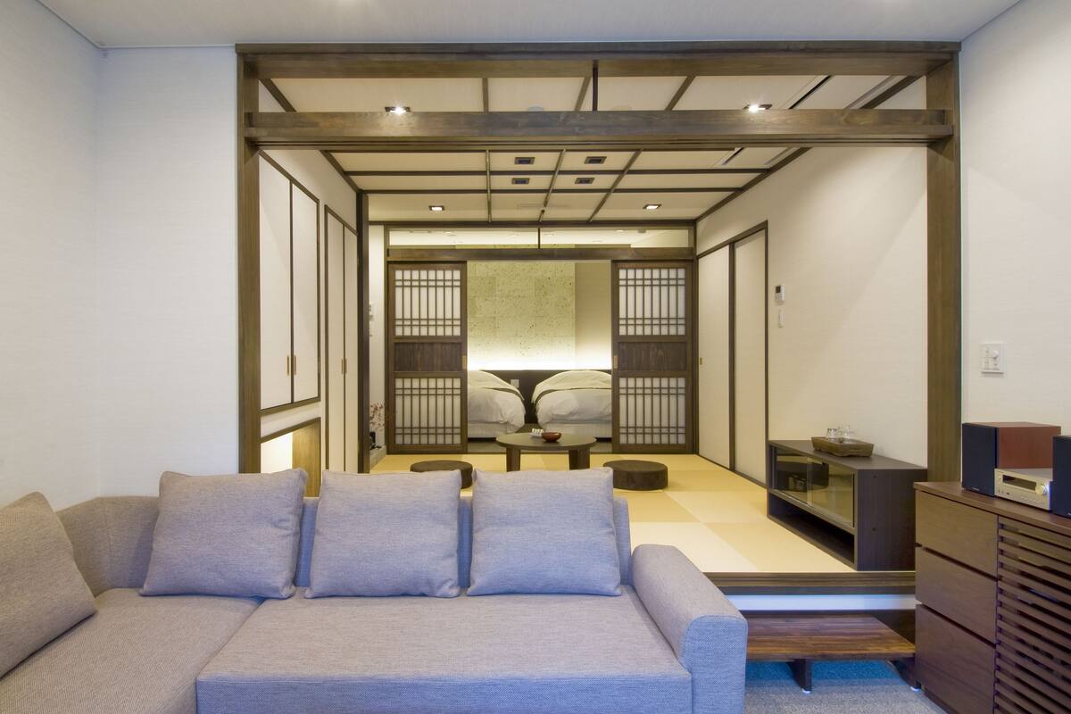 A modern living room with a sofa, a coffee table, and a TV stand.