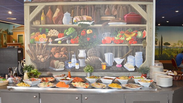 A buffet setup with various food items and kitchenware displayed on shelves and counters.