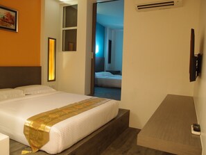 A hotel room with a bed, a bedside table, a TV mounted on the wall, and a window with a view of another room. - Hotel 193 (Johor Bahru)