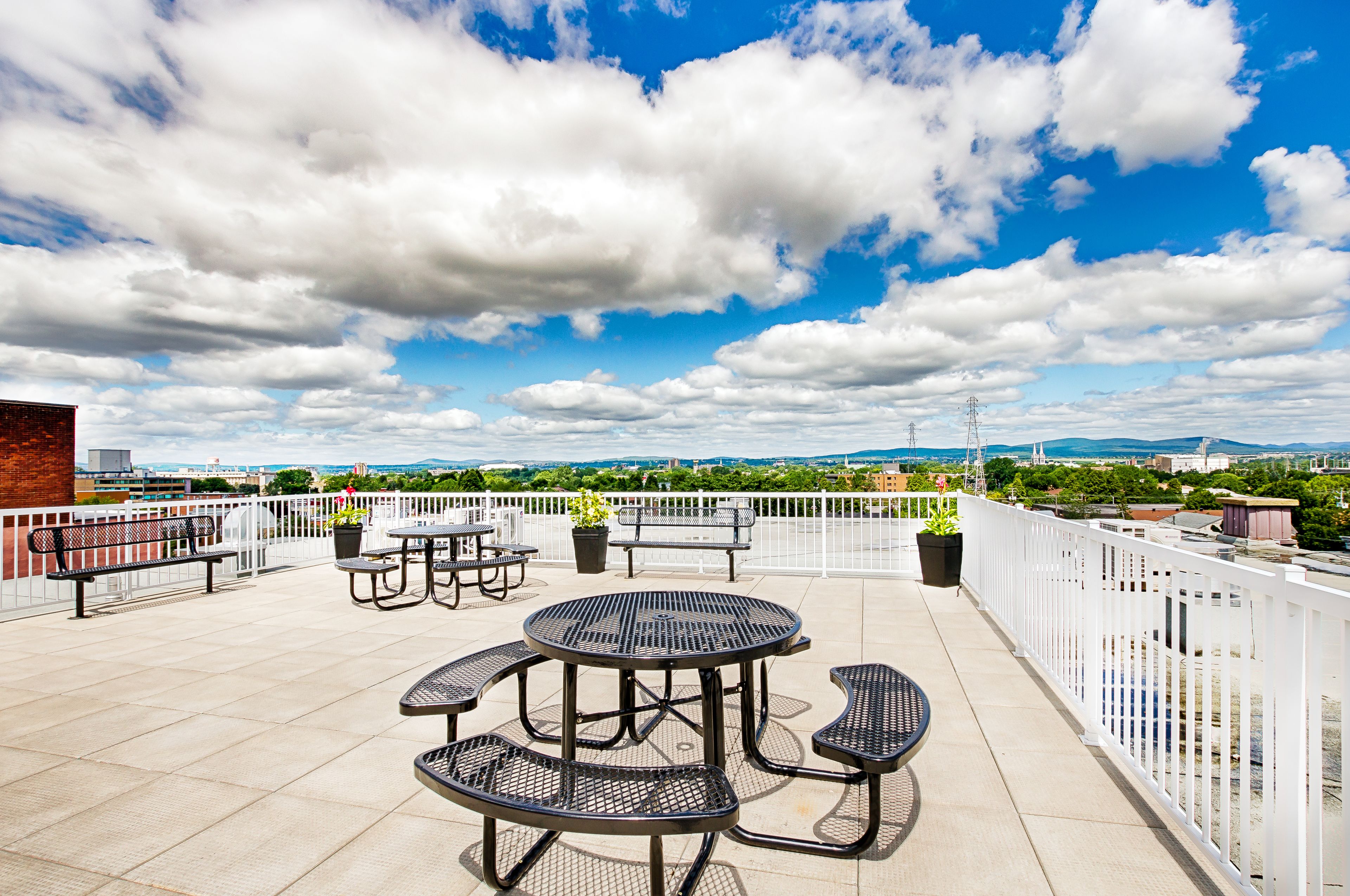 Une terrasse sur le toit, avec des sièges en plein air et une vue sur le paysage urbain.