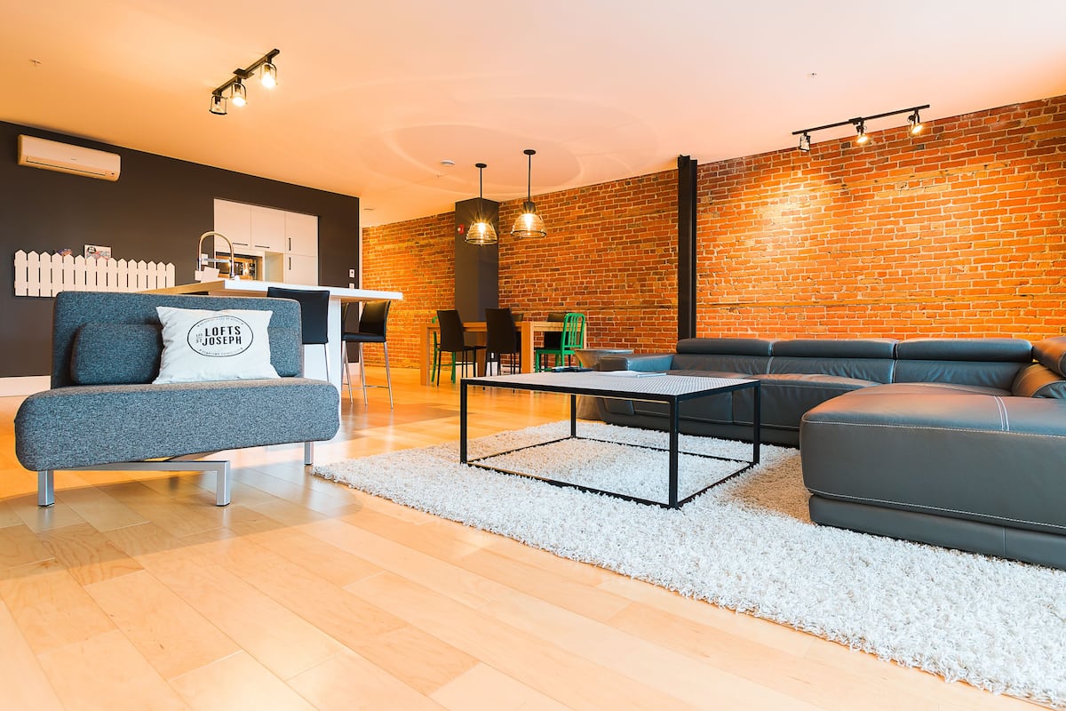 Una sala de estar moderna con un sofá, una mesa de centro y un comedor con sillas y una mesa.