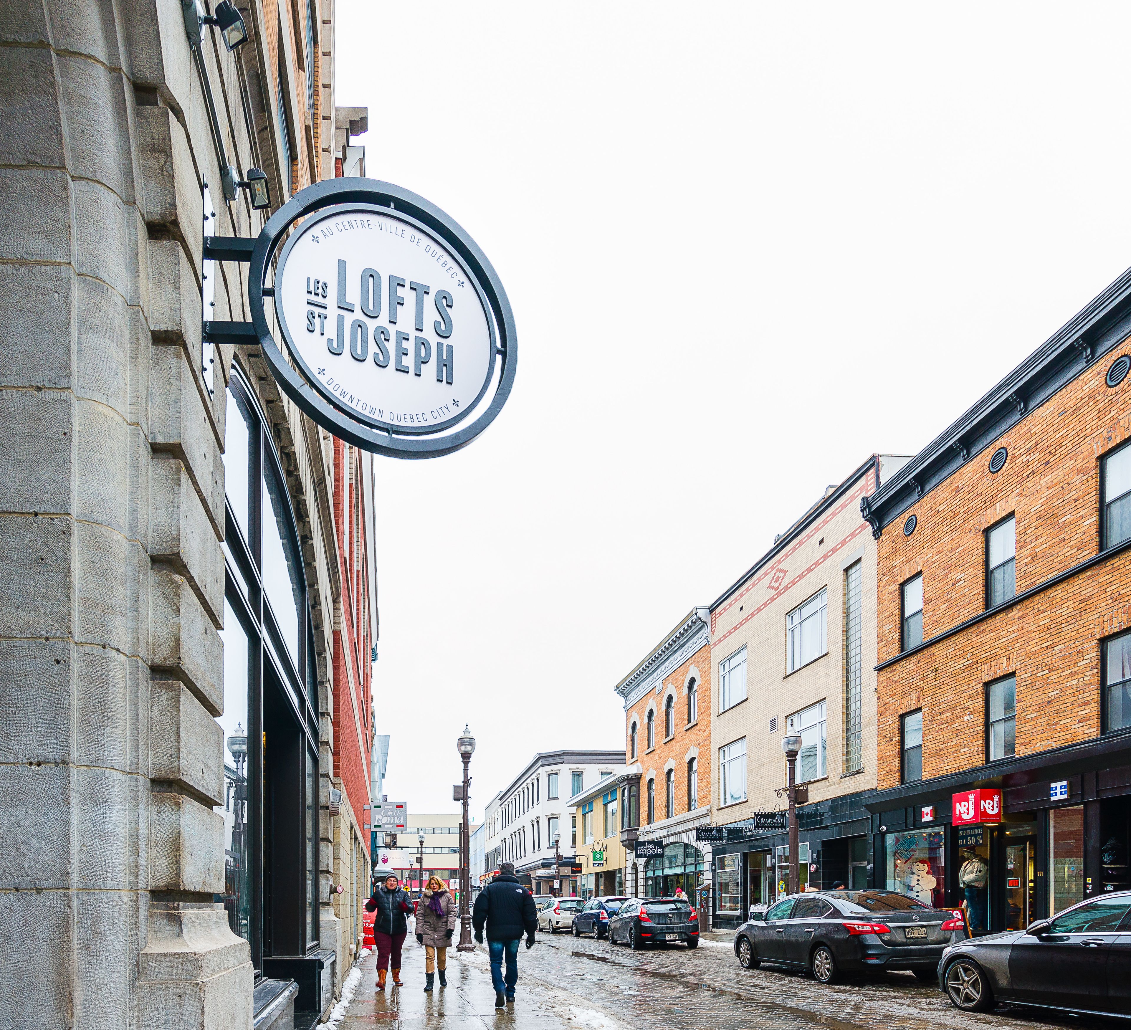A street scene with a sign for 'Lofts St. Joseph' in downtown Quebec City.
