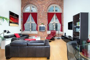 Romantisk loftsrom (Loft #206) | Oppholdsområde | En 30-tommers Flatskjerm-TV med kabel-kanaler samt TV