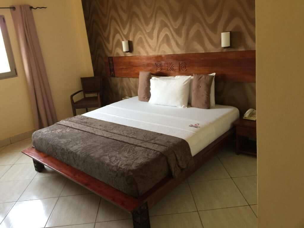 A bed with a wooden headboard, a bedside table, and a chair.
