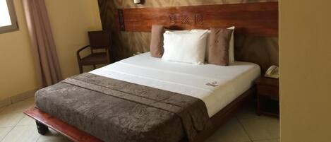 A bed with a wooden headboard, a bedside table, and a chair.