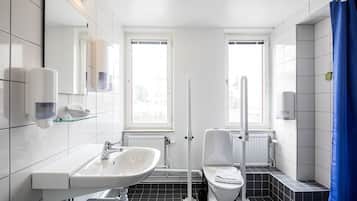 Un baño moderno con lavamanos, inodoro y cortina de ducha blancos.