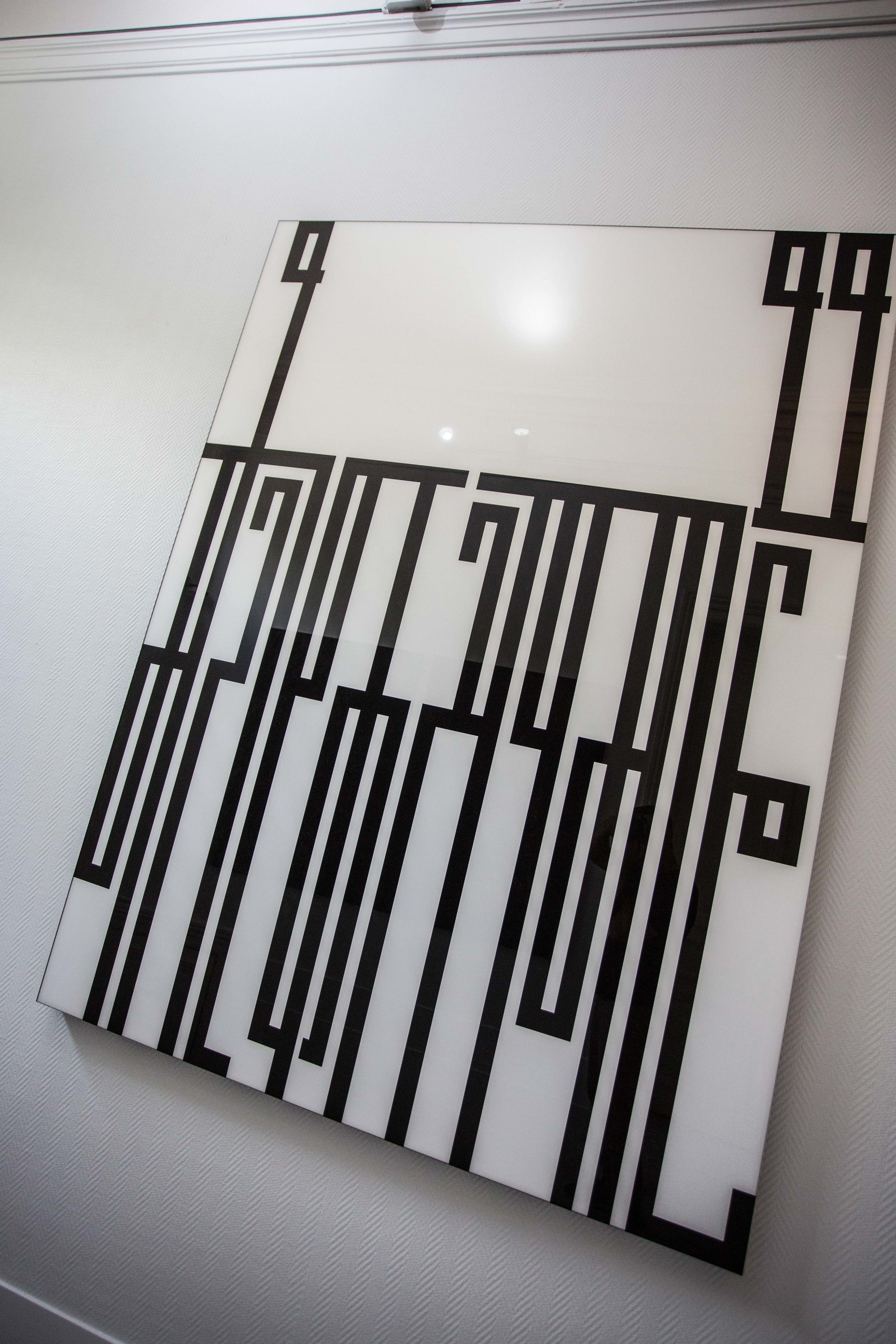 Una instalación artística geométrica con líneas negras sobre fondo blanco.