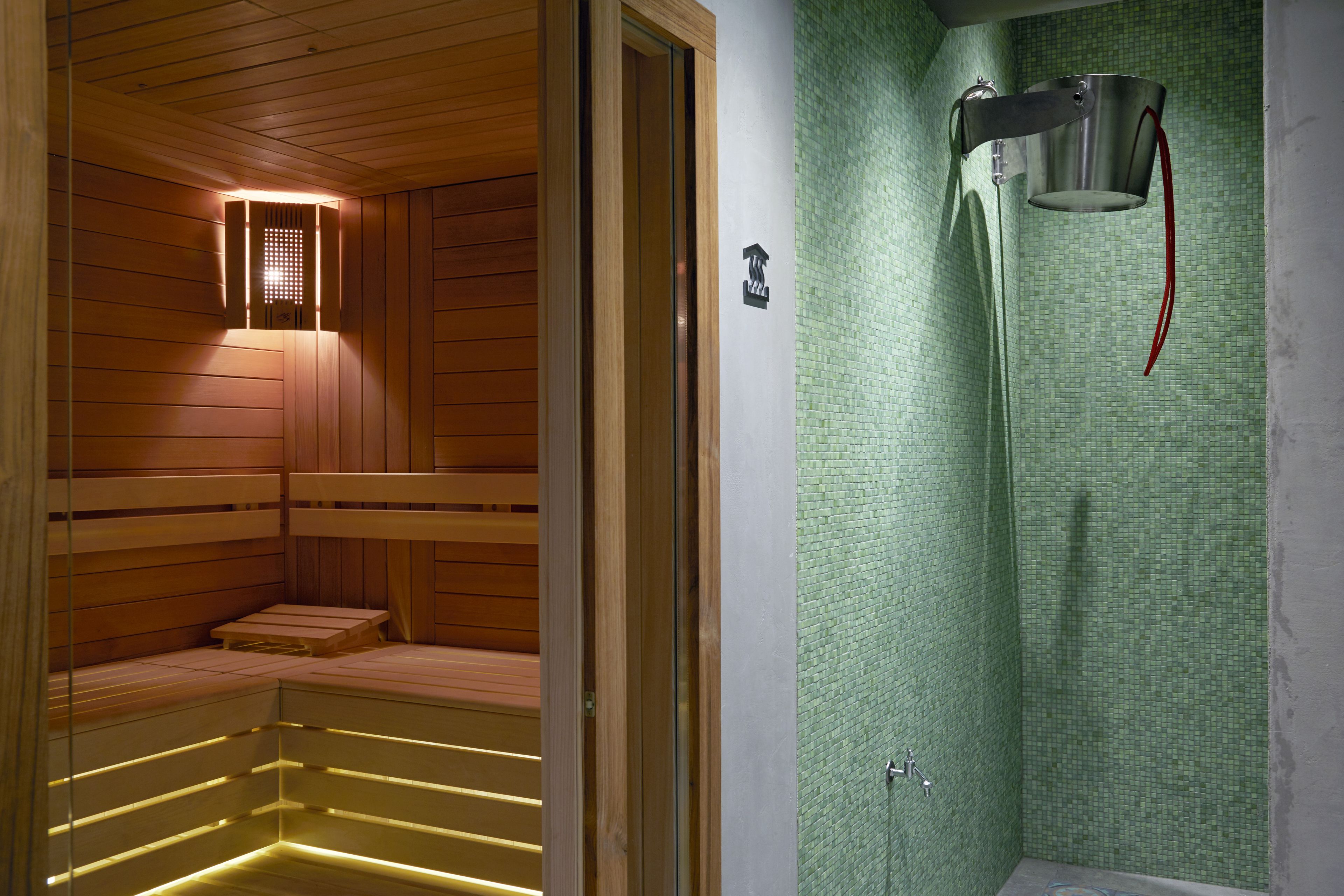 A sauna with wooden benches and a tiled wall.