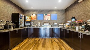 A modern kitchen with dark cabinets, a wooden floor, and a central island.