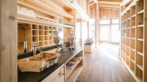 A wooden interior with a long counter, shelves with glassware, and a large mirror. - Feriendorf Ponyhof (Fusch an der Grossglocknerstrasse)