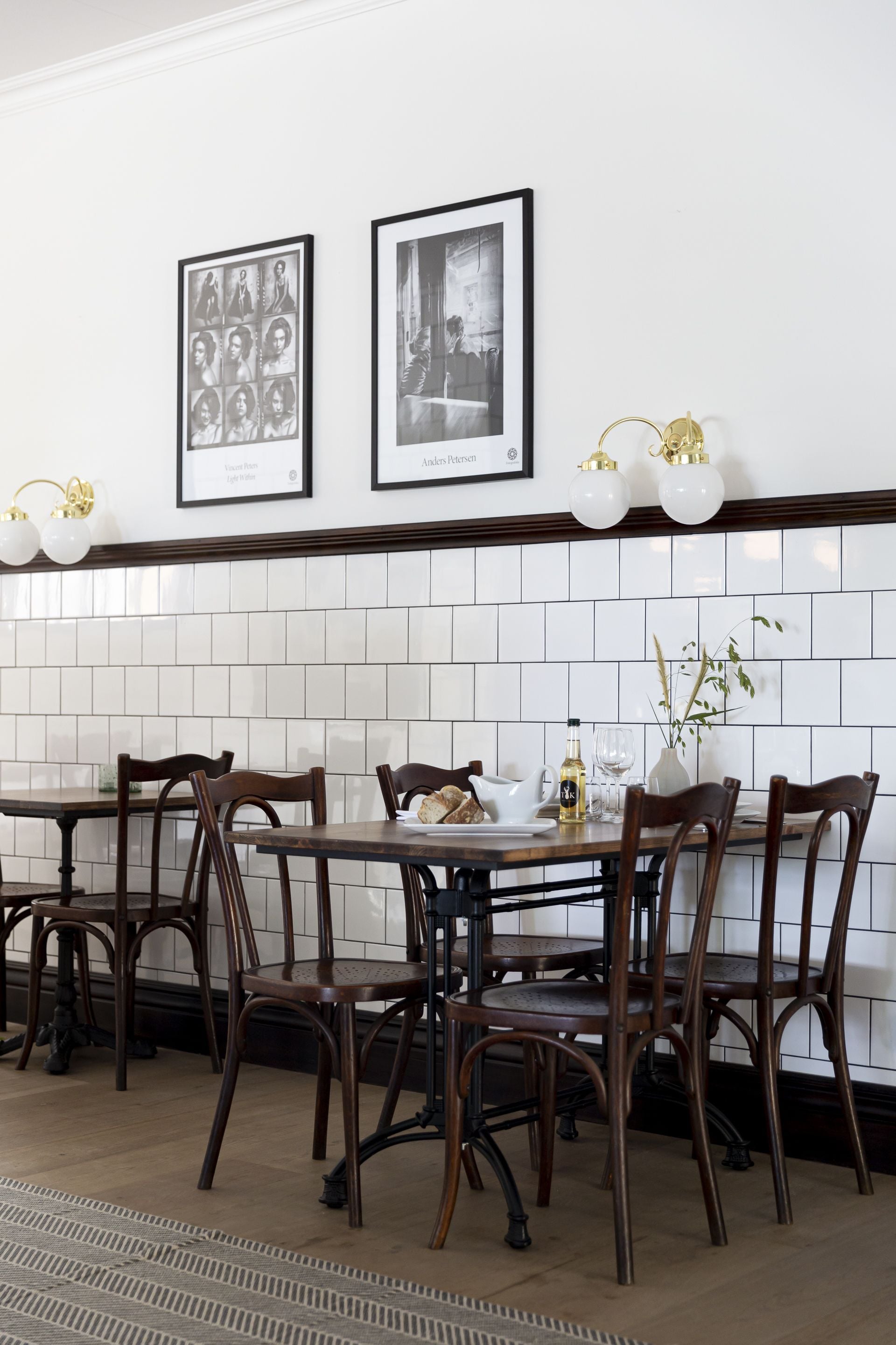 A dining area with a long table, wooden chairs, and a tiled backsplash.