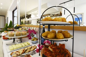 A buffet with various food items including croquettes, salads, and bread. - Best Western Hotel Martello (Lampedusa)